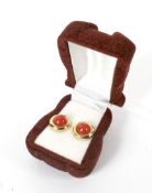 A pair of yellow metal and coral stud earrings. Stamped '375',