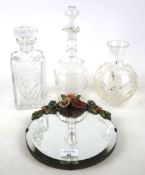 A small wall mirror, glass vase and two decanters.