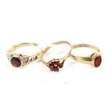 Three 9ct gold rings. Each set with red stones, including a cluster example,