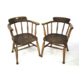 A pair of early 20th century oak captain's chairs.