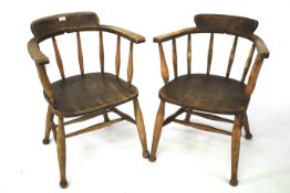 A pair of early 20th century oak captain's chairs.