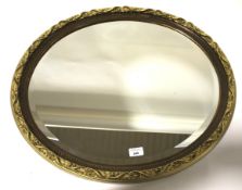 A decorative oval gilt framed wall mirror, with a foliate decoration,