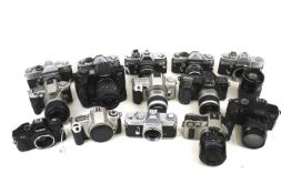 A collection of fourteen Canon, Minolta and Petri 35mm SLR cameras.