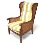 A contemporary beech effect wingback cane work elbow chair.