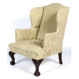 A Georgian style wingback upholstered armchair.