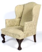 A Georgian style wingback upholstered armchair.
