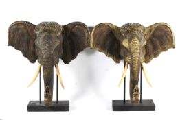 A pair of large contemporary carved wooden elephant heads.
