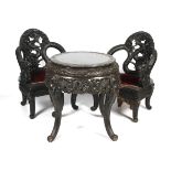 A 20th century Chinese carved hardwood drum table and two dragon throne chairs.