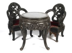 A 20th century Chinese carved hardwood drum table and two dragon throne chairs.