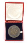An 1897 Diamond Jubilee large silver medallion in a red box.