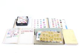 A world collection of assorted stamps in albums and a tin of loose stamps