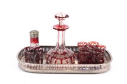 A Bohemian engraved ruby flashed decanter and matched glasses on a tray.