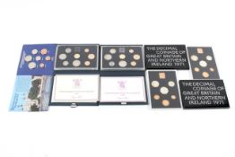 Four proof sets of coins and a 1982 Brilliant uncirculated set.