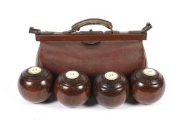A vintage 20th century Gladstone-style bag and a set of four lignum vitae bowls.