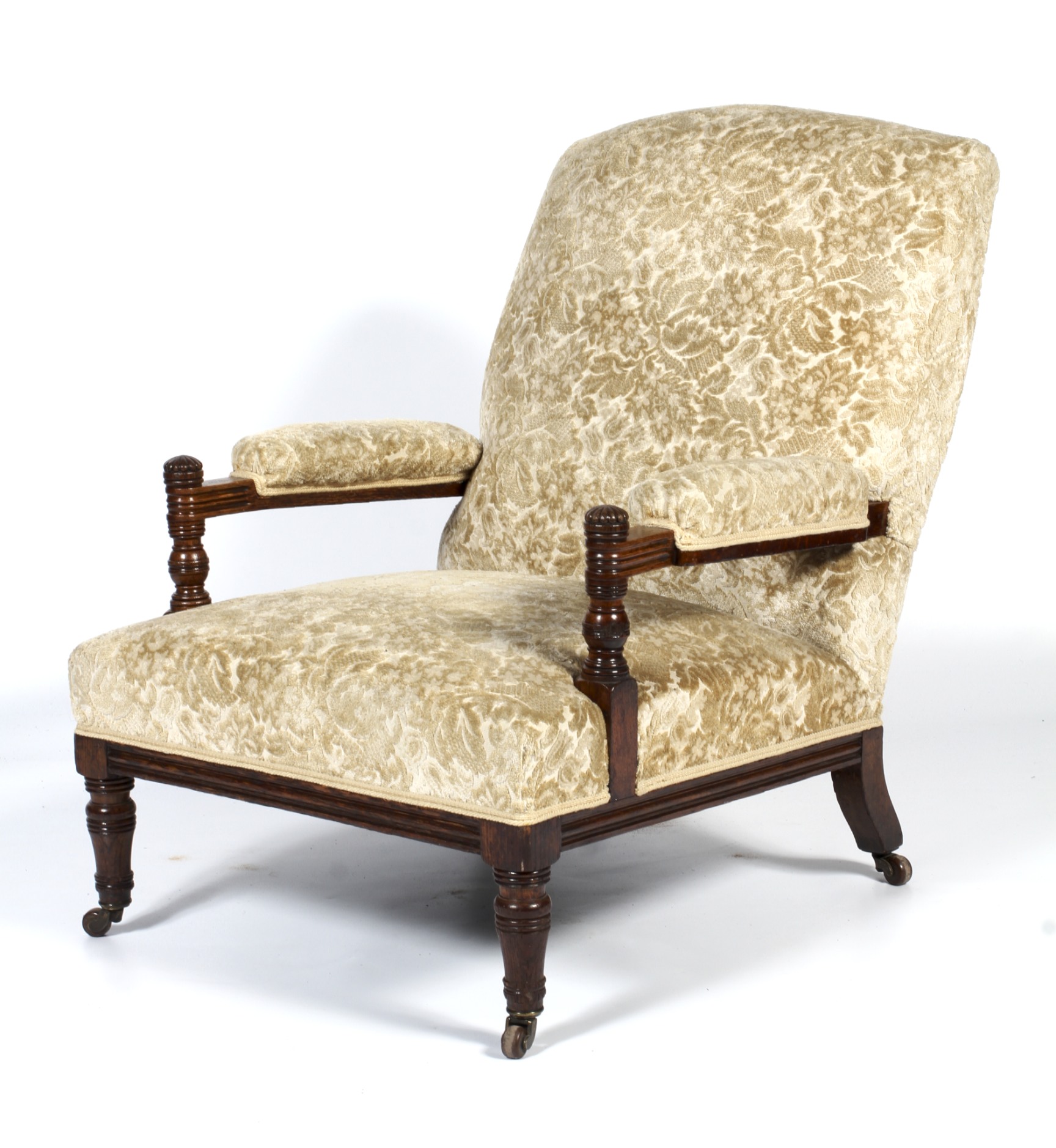 An Edwardian oak framed upholstered armchair.