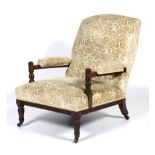 An Edwardian oak framed upholstered armchair.