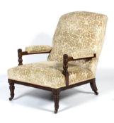 An Edwardian oak framed upholstered armchair.