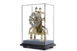 A 20th century eight-day brass skeleton clock on ebonised stand within a glass case.