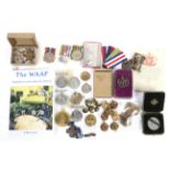 A collection of assorted medals, cap badges and military buttons.