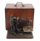 A vintage hand crank small table top chain stitch sewing machine.