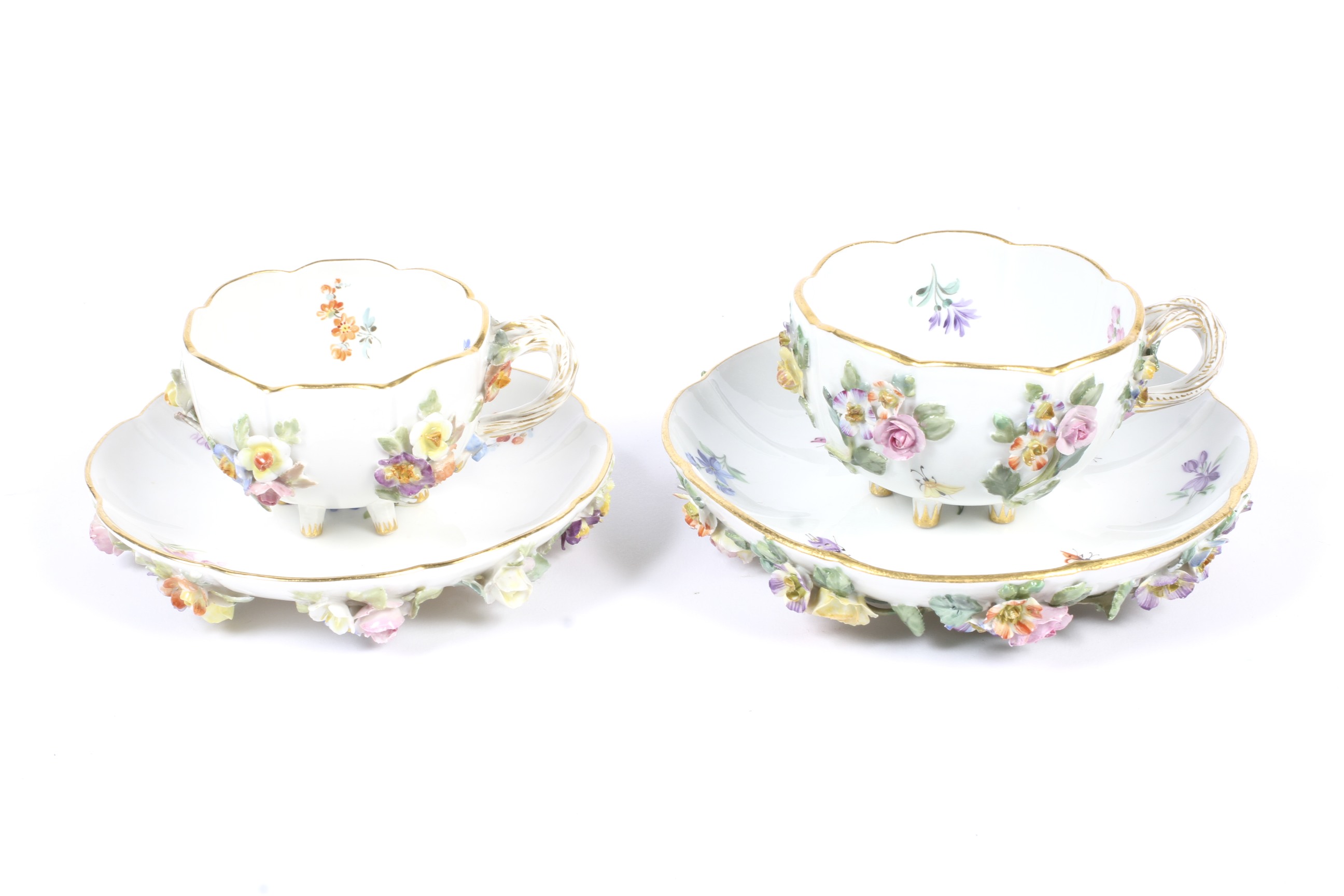 Two late 19th century Meissen flower encrusted teacups and saucers.