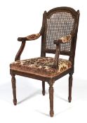 A 19th century Louis XVI style dark stained carved armchair.