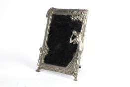 A white metal mirror frame in the WMF Art Nouveau style.