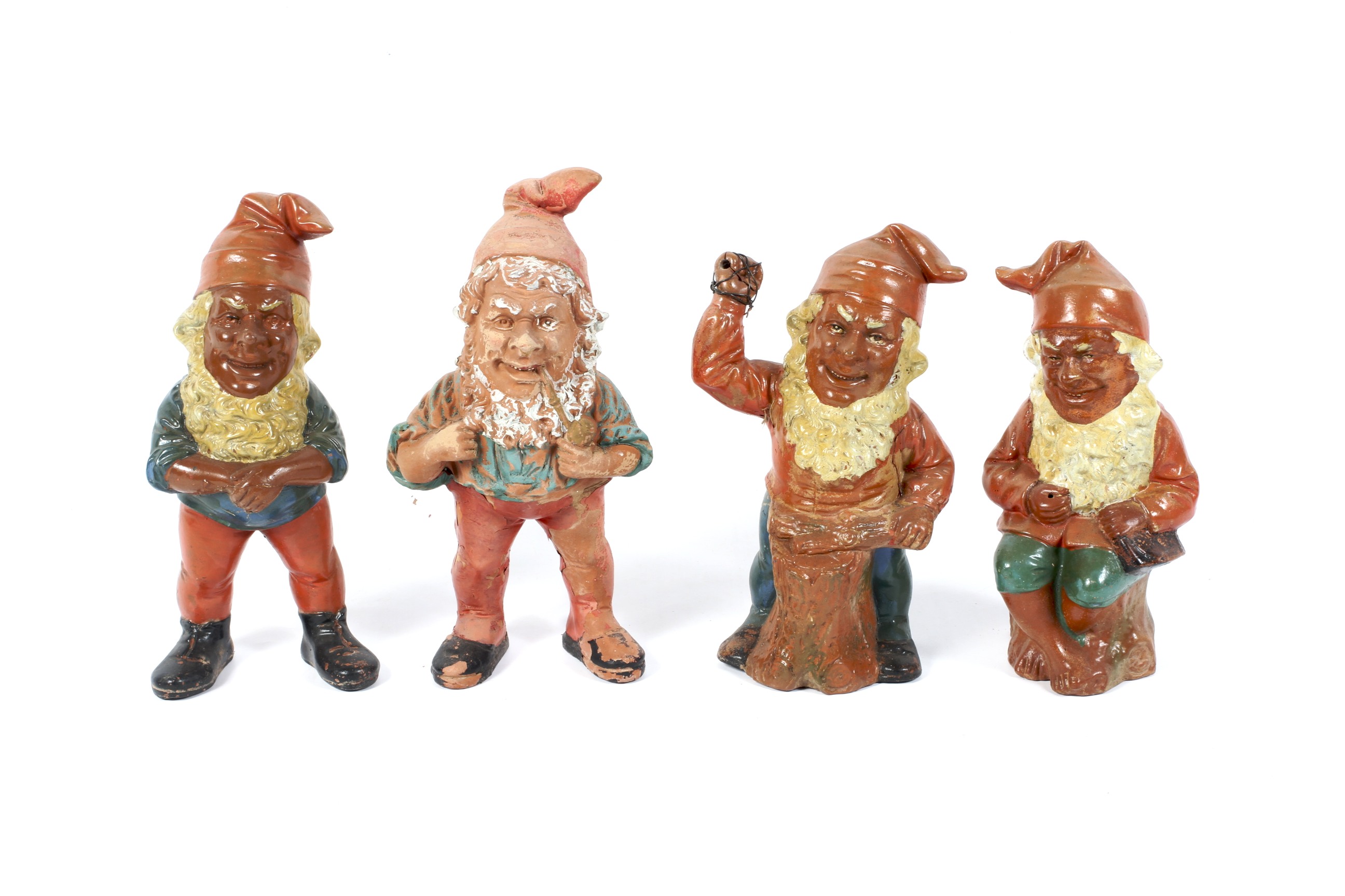 Four late 19th/early 20th century Continental terracotta gnomes in various poses. H27cm.