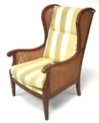 A contemporary beech effect wingback cane work elbow chair.