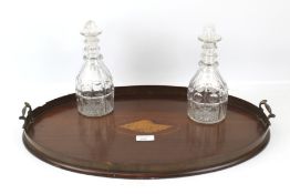 A 19th century twin handled mahogany tray and a pair of decanters.