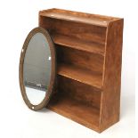 A 20th century wooden bookcase and bevelled edge wall mirror.