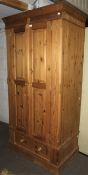 A pine wardrobe, complete with rail and drawer.