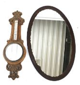 An Edwardian oak mirrored banjo barometer and an oval mirror.