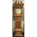 A pine cupboard in the form of a longcase clock.