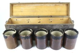A long rectangular wooden box containing five saltglaze stoneware jars.