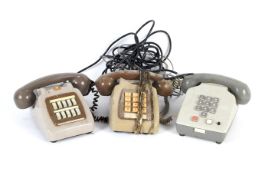 Three assorted vintage two tone push button electronic telephones.