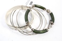 A collection of five ladies silver and white metal bangles.