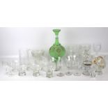 An assortment of glassware. Including drinking glasses, desert dishes, a green vase, etc.