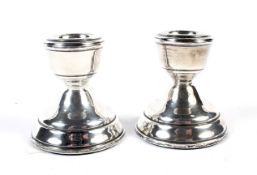 A pair of silver weighted candlesticks. Of squat form, hallmarked Birmingham 1971, H6.