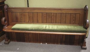 A carved wooden pew, complete with cushion. L177cm.