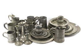 An assortment of pewter. Including tankards, a pair of candlesticks, plates, etc.