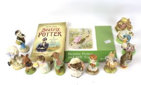 An assortment of ten Beatrix Potter figures and two books.