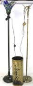 Two contemporary floor lamps and an umbrella stand.