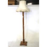 An Art Deco blond oak standard lamp with shade.