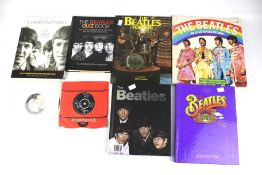 Two Beatles 45rpm 7" singles and a collection of related books.