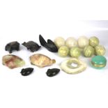 A collection of eight assorted stone eggs and some stone carved animals.