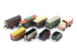 Five O gauge tinplate carriages, two tenders and a freight car.