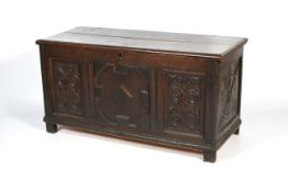 A carved oak coffer. With hinged plank t