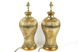 A pair of contemporary gilt finish table lamps.