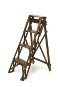 A vintage pair of wooden folding step ladders.